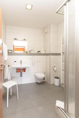 ein Badezimmer mit Toilette, Waschbecken und Dusche in der Unterkunft Hotel Zehnthof in Ürzig