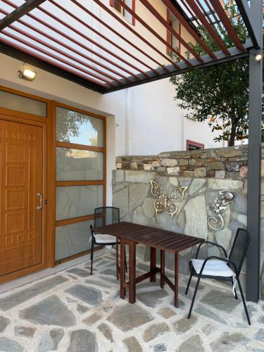 een patio met een houten tafel en 2 stoelen bij Cullura in Asklipiḯon