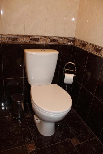 a white toilet in a black tiled bathroom at Гаряча вода та опалення є без світла Elit Aparts on Pushkina WIFI in Dnipro