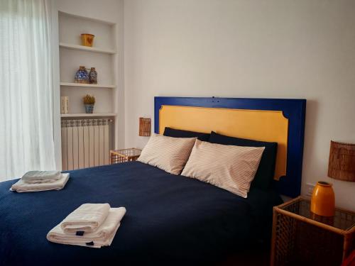 a bedroom with a blue bed with towels on it at B&B Mareluce in Torre del Greco