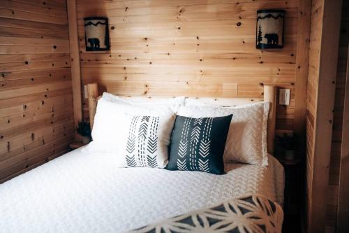 a bed in a room with a wooden wall at Cozy Cub Cabin, Wilderness Retreat Williams AZ near Grand Canyon, Fire pit in Williams