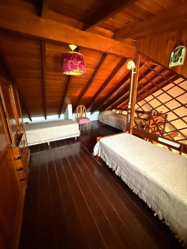 a attic room with two beds and a chandelier at CASA El CORRALÓN in Las Toninas