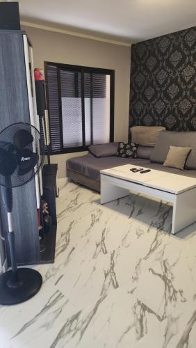 ein Wohnzimmer mit einem Bett und einem Marmorboden in der Unterkunft MI CASITA de Lanzarote in Arrecife