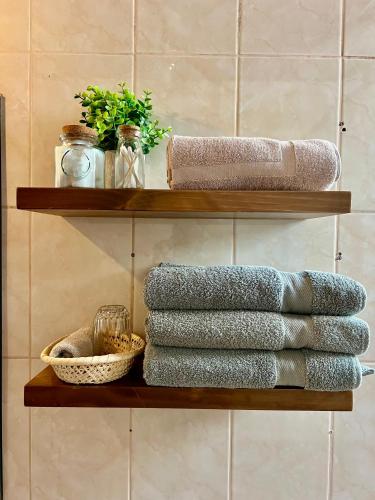 a stack of towels on a shelf in a bathroom at Casa Encuentro San Blas in Cusco