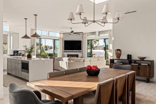 a kitchen and living room with a wooden table and chairs at Desert Oasis: Pool, Spa, Golf Sim + EV Charger in Bermuda Dunes