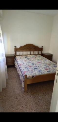 een slaapkamer met een bed met een houten hoofdeinde bij PH en Mar de Ajó Centro in Mar de Ajó