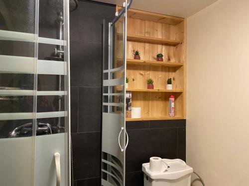 a shower with a glass door in a bathroom at L'atelier des couleurs in Vagney