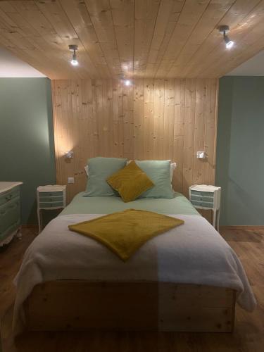 a bedroom with a large bed with a wooden ceiling at L'atelier des couleurs in Vagney