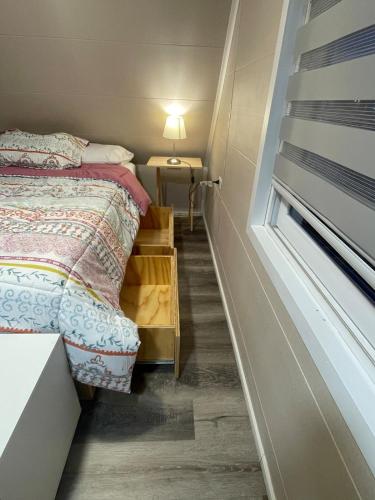 a small bedroom with a bed and a window at Departamento interior in Puerto Montt