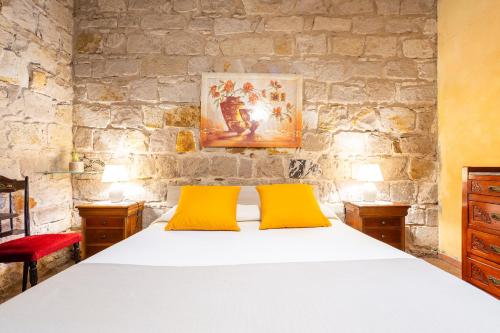 a bedroom with a bed with two yellow pillows at Domus de Janas Rooms Gonnesa in Gonnesa