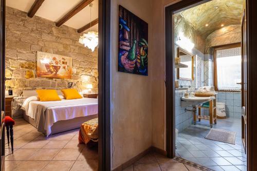 Un dormitorio con una cama en una pared de piedra. en Domus de Janas Rooms Gonnesa, en Gonnesa