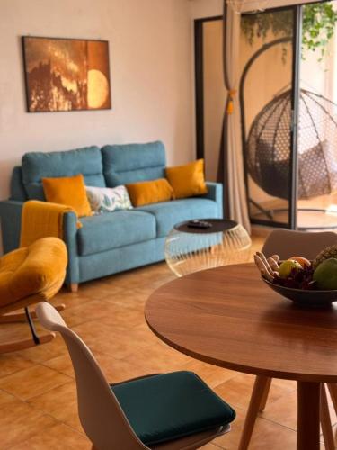 een woonkamer met een blauwe bank en een tafel bij Ti Paradis Doré in Schœlcher