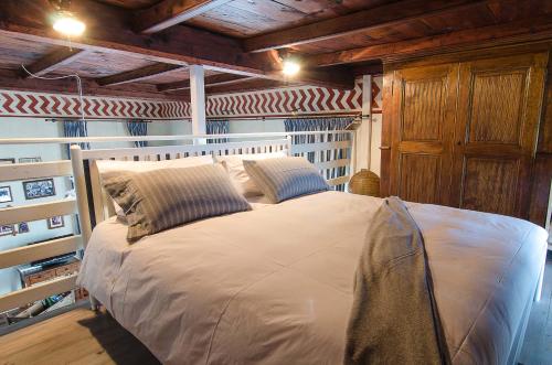 Cama grande en habitación con techo de madera en B&B Chocolat au lac, en Omegna