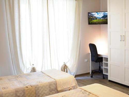 a bedroom with two beds and a desk and a window at Villa Lidia Teramo in Teramo