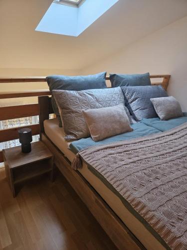 uma cama com almofadas azuis num quarto em Pod strechou Kysúc em Oščadnica