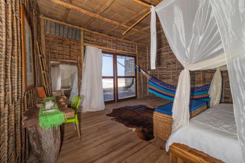 a bedroom with a bed and a hammock in a room at Ipuana Virgin Beach in Manaure