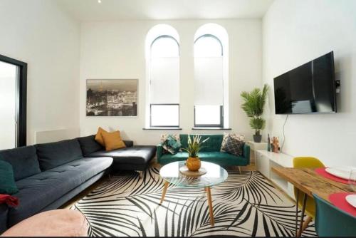 a living room with a couch and a table at Central Leeds 2 Bed Apartment Sleeps 6 in Leeds