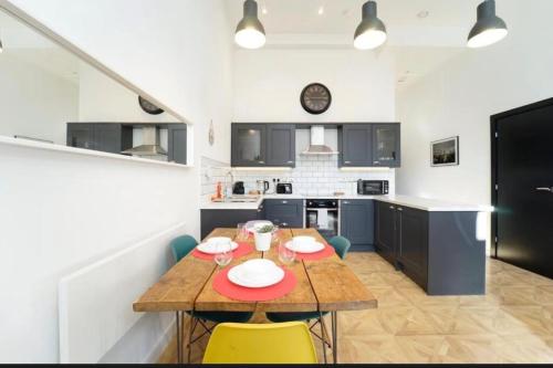 a kitchen with a wooden table and yellow chairs at Central Leeds 2 Bed Apartment Sleeps 6 in Leeds