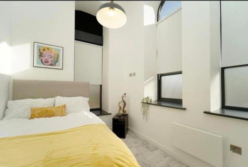 a bedroom with a large bed and windows at Central Leeds 2 Bed Apartment Sleeps 6 in Leeds