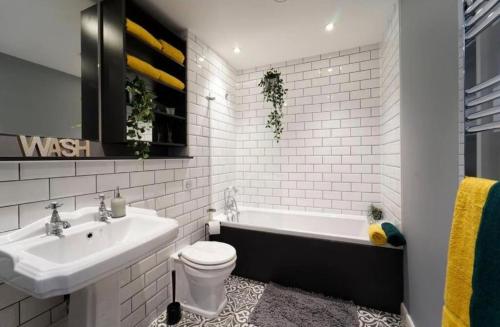 a bathroom with a sink and a tub and a toilet at Central Leeds 2 Bed Apartment Sleeps 6 in Leeds