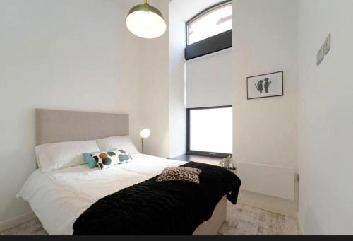 a bedroom with a bed with a black blanket on it at Central Leeds 2 Bed Apartment Sleeps 6 in Leeds