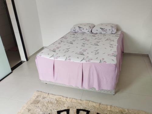 een bed in een kamer met een roze bedkap bij Suíte 4 Centro de São Thomé das Letras in São Thomé das Letras