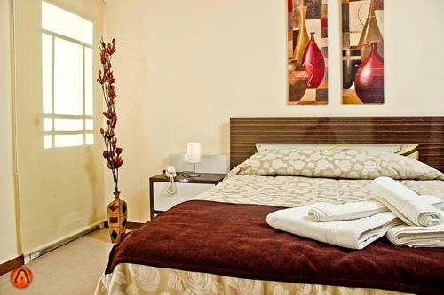 a bedroom with a large bed with two towels on it at Hotel Esmeralda in Piriápolis