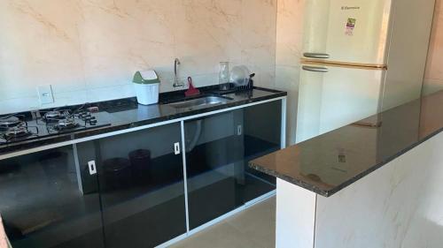 una cucina con lavello e frigorifero di loft 2 sitio do barrigudinho a Saquarema