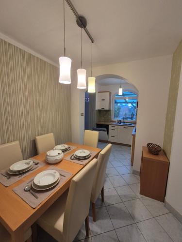 a dining room with a wooden table and chairs at Gyékény Pihenő in Szarvas