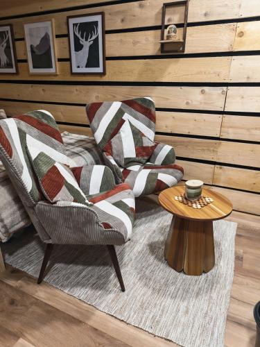 ein Wohnzimmer mit einem Stuhl und einem Tisch in der Unterkunft Studio Stylisé Chalet in Rochejean