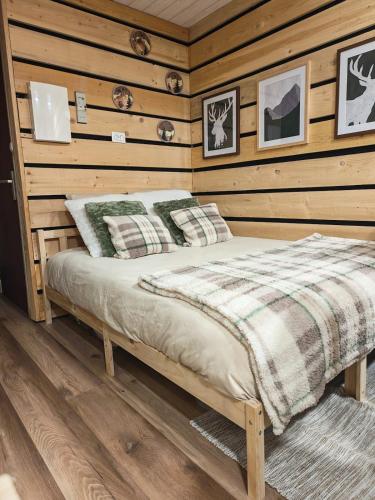 a bedroom with a bed in a wooden wall at Studio Stylisé Chalet in Rochejean