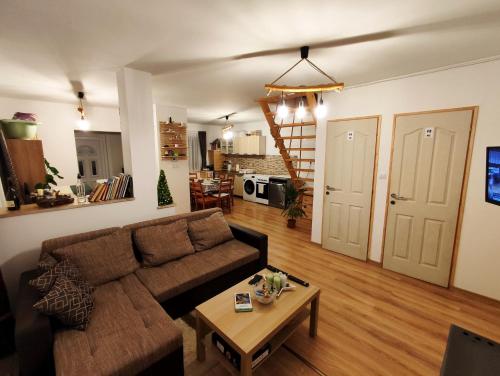 a living room with a couch and a table at Forest Cottage 2024 in Lábatlan