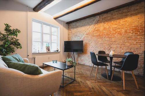 a living room with a couch and a brick wall at Luxury apartment with sea view - 3 rooms in Hillerød