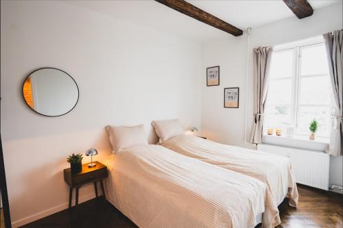 a white bedroom with a bed and a mirror at Luxury apartment with sea view - 3 rooms in Hillerød