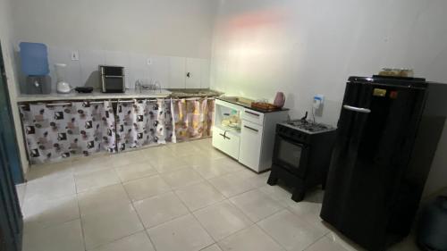 een keuken met een zwarte koelkast en een fornuis bij Nunes stay in Prado