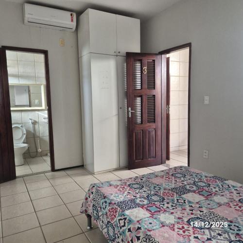 Casa de Condomínio Privativo في فورتاليزا: غرفة نوم بسرير وحمام مع مرحاض