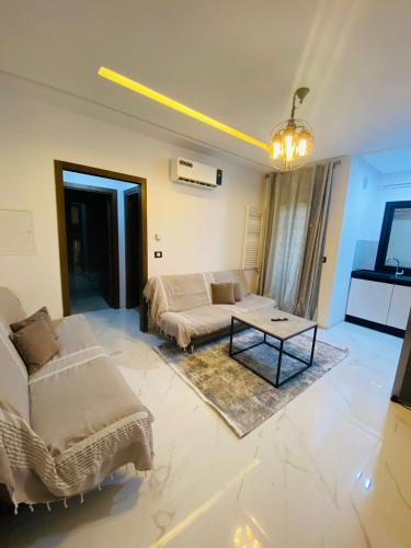 een woonkamer met een bank en een tafel bij Dar awina in Bin Rhilouf