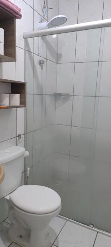 a white bathroom with a toilet and a shower at Casa de Benê in Tramandaí
