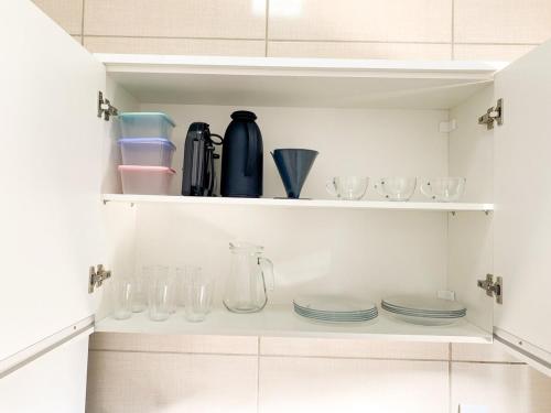 a cupboard filled with dishes and glassware at Apto Compacto Ótimo Custo-Benefício in Guaíra