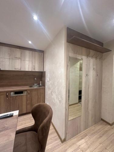 a kitchen with a table and a chair in a room at MB Apartmani Kopaonik in Kopaonik