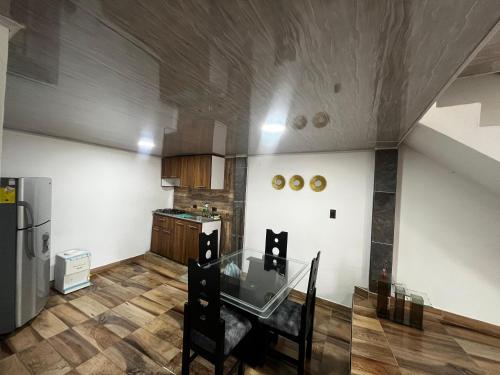 uma cozinha com uma mesa de vidro e um frigorífico em la terraza em Armenia