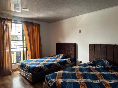 duas camas uma ao lado da outra em um quarto em la terraza em Armenia