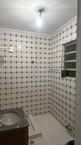 baño con lavabo y pared de azulejos en Hostel San Pietro, en Santos