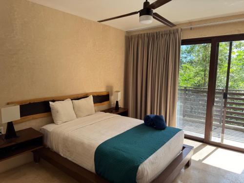 a bedroom with a bed and a large window at Albra Tulum in Tulum