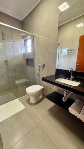 ein Badezimmer mit Toilette, Dusche und Waschbecken in der Unterkunft Hotel Tamboril in Barra Bonita