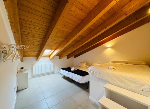 um quarto com duas camas e um teto de madeira em El Sueño De Albarracín II Duplex em Albarracín