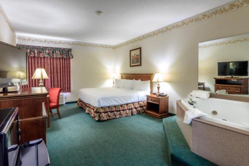 a hotel room with a bed and a bath tub at Branson Towers Hotel in Branson
