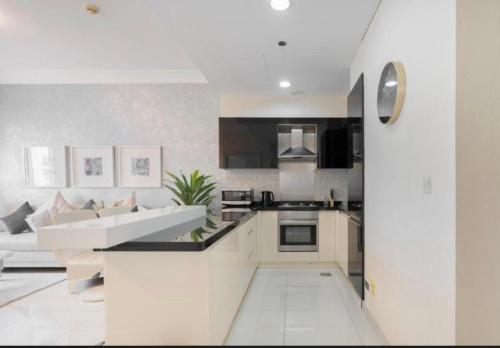 a kitchen with white cabinets and a white couch at رويال علاء للشقق الفندقيه in Dubai