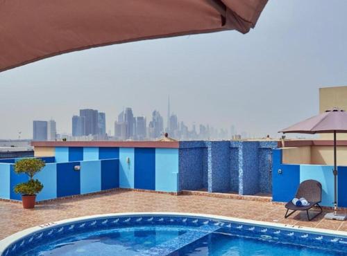 a swimming pool on top of a building with a city skyline at رويال علاء للشقق الفندقيه in Dubai