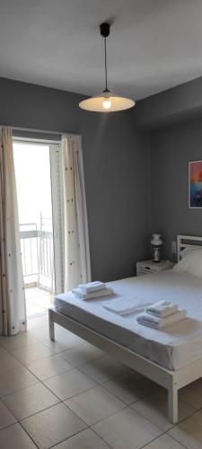 a bedroom with a bed and a large window at Parastaseis City Apartment Central in Patra